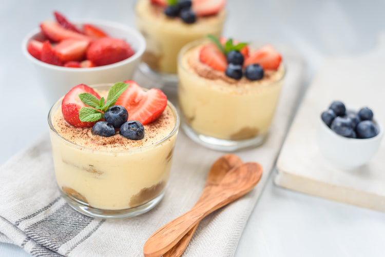 Mousse-Creme im Glas, mit Erdbeeren, Blaubeeren und Minze dekoriert.