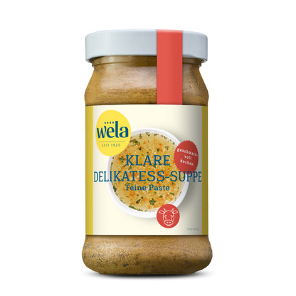 Wela Klare Delikatess-Suppe Feine Paste - Glas mit heller Suppenpaste, gelb-weißem Vorderseitenetikett, roter Banderole, Motiv einer Brühe.