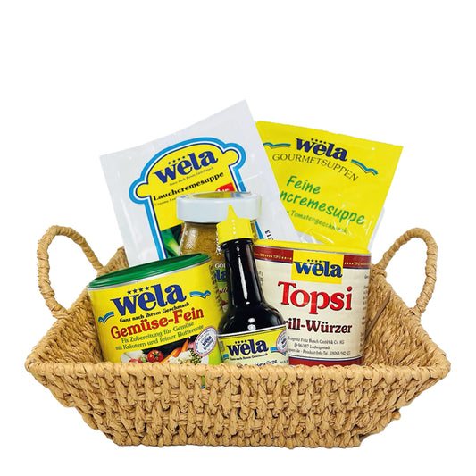 Wela Präsentkorb Junior mit verschiedenen Produkten – Glas, Beutel, Dosen und eine kleine Flasche im Weidenkorb.