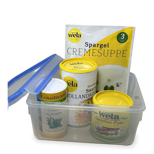 Aufbewahrungsbox mit Wela Lebensmitteln: Spargelcremesuppe, Sauce Hollandaise, Gemüse-Fein und Kräutersalz mit blauem Deckel.